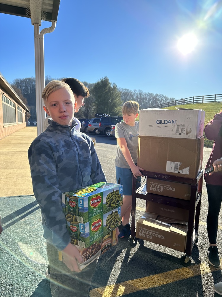Students loading canned food onto a cart